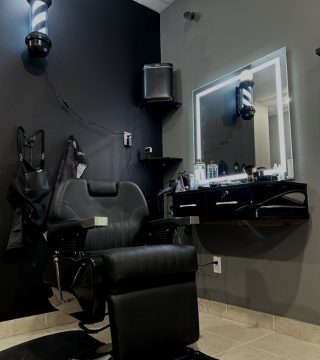 A barber chair positioned in a room featuring a mirror and a sink, creating a classic barbershop atmosphere.